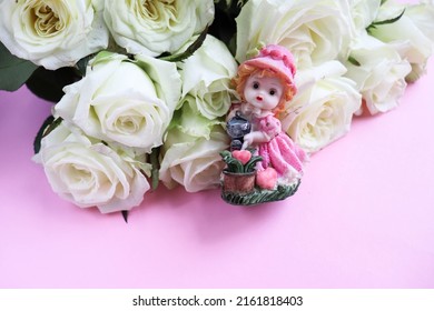 A Bouquet Of White Roses And A Porcelain Figurine