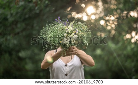 Similar – Woman making wild flowers at home in vase