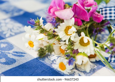 Bouquet wild flowers on blue table cloth