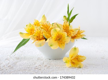 Bouquet Of Yellow Flowers Is In A White Vase On The Table
