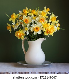 a bouquet of yellow garden daffodils in a white jug. spring flowers.