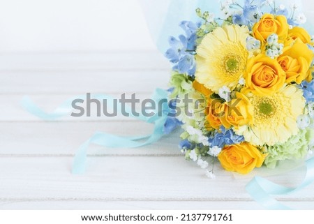 A bouquet of yellow and light blue flowers.