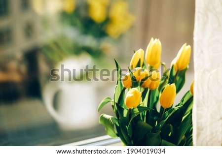 Bouquet of yellow tulip flowers on window sill