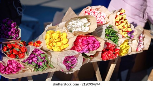 Bouquets of tulips, different colors of spring flowers for sale at city street. Colorful tulips at flower market. International women's day concept