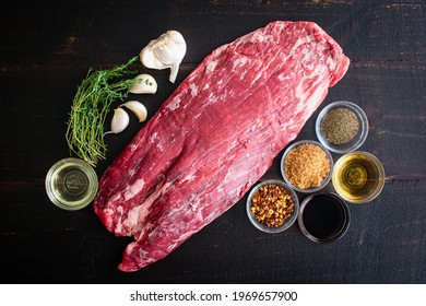 Bourbon Marinated Grilled Flank Steak Ingredients: Raw Flank Steak, Herbs, And Other Ingredients On A Dark Wood Background