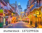 Bourbon St, New Orleans, Louisiana, USA cityscape of bars and restaurants at twilight.