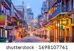 Bourbon St, New Orleans, Louisiana, USA cityscape of bars and restaurants at twilight.