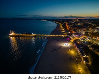 Bournemouth Pier, Beach And Promenade In Dorset, UK At Night With Beautiful Sunset, Fairground Rides, People Walking On Wooden Pier - HDR