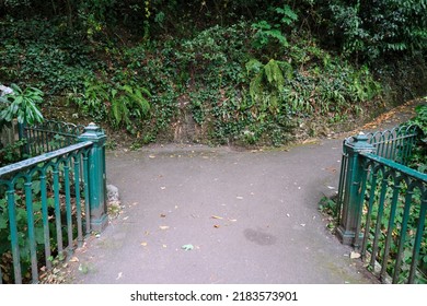 Bournemouth, UK - July, 2022: A fork on the pathway at a small bridge in a leafy area in Alum Chine