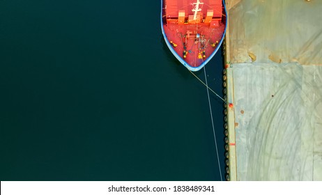 Bow of a cargo ship at port with mooring lines securing the vessel to the bollards on the dock. Aerial view. - Shutterstock ID 1838489341