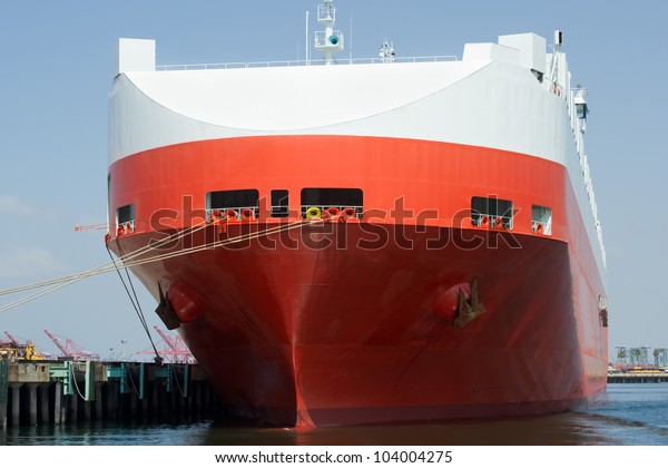 The bow of a large roll-on/roll-off\
(RORO or ro-ro) car carrier ship docked in a\
harbor