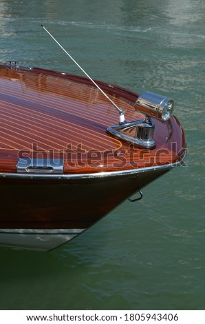 Bow of a motorboat in polished wood with chrome details
