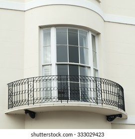 Bow window with narrow balcony set on a white building