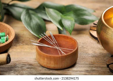 Bowl with acupuncture needles on wooden table - Powered by Shutterstock