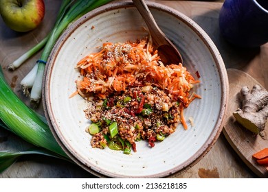 A Bowl Of Apple Carrot Salad And A Wooden Spoon.