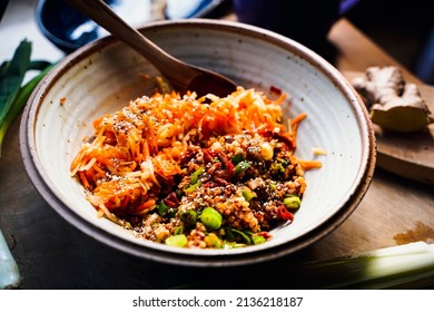 A Bowl Of Apple Carrot Salad And A Wooden Spoon.