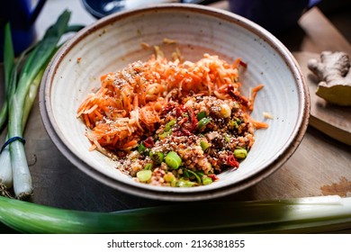 A Bowl Of Apple Carrot Salad And A Wooden Spoon.