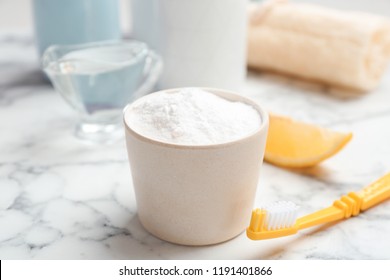 Bowl With Baking Soda And Toothbrush On Marble Table