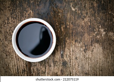 Bowl Of Balsamic Vinegar On Wooden Table