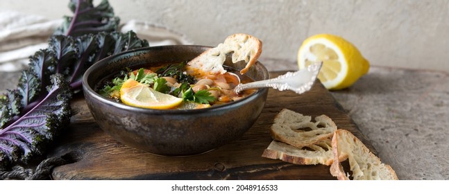 A Bowl Of Bean Soup With Kale On The Table