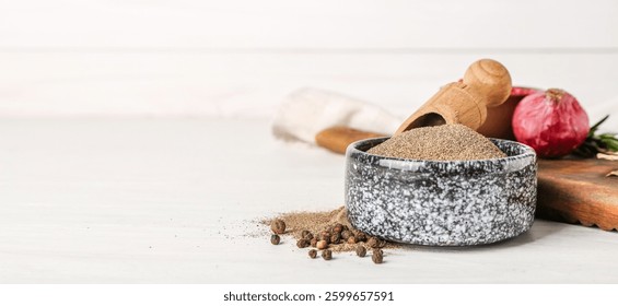 Cuenco con polvo de pimienta negra sobre fondo de madera blanco con espacio para texto