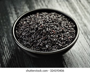 Bowl Of Black Rice On Black Wooden Table