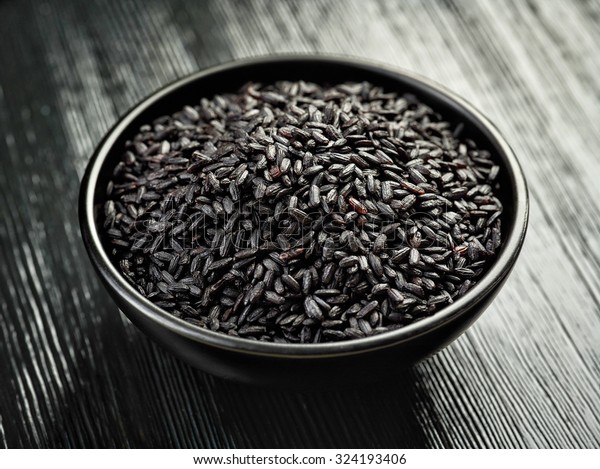 bowl of black rice on\
black wooden table