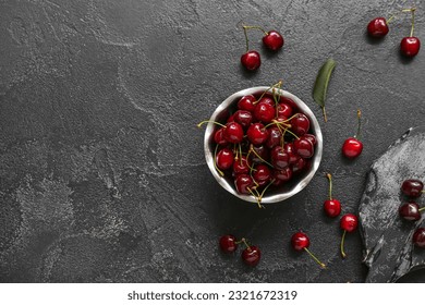 Bowl and board with sweet cherries on black background - Powered by Shutterstock