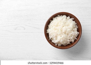 Bowl Of Boiled Rice On Wooden Background, Top View With Space For Text