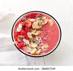 Bowl Of Breakfast Smoothie On White Wooden Table, Top View