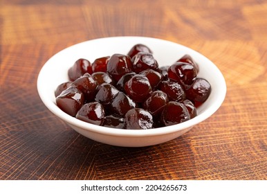 Bowl of Brown Sugar Tapioca Pearl Balls Used in Boba Tea on a Wooden Table - Shutterstock ID 2204265673