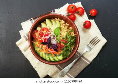 Bowl with bulgur, cherry tomatoes, slices of avocado, cucumber, carrot, arugula and basil on a dark surface. Useful and tasty diet food. - Shutterstock ID 1160999494