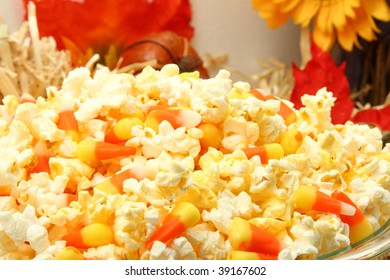 Bowl Of Butter Popcorn And Candy Corn Mixture.  Autumn Colors And Hay In Background.