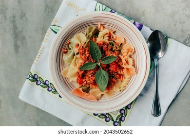 Bowl Of Butterfly Bow Tie Pasta With Red Bolognese Sauce. Hand Towel With Olives In The Backround