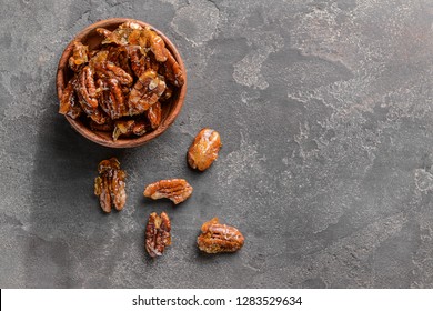 Bowl With Candied Pecan Nuts On Grey Background