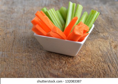 Bowl Of Carrot And Celery Sticks On Wooden Background