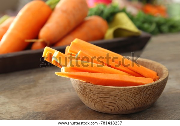 Bowl with carrot\
sticks on table, closeup