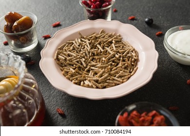 Bowl of cereal bran stick, yogurt, honey and dried fruits on black background - Powered by Shutterstock