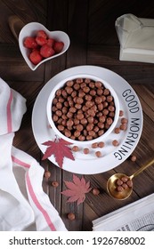 bowl of cereal, with Good Morning text on the white plate. dark background. wood table. top view.