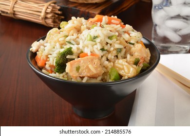 A Bowl Of Chicken Teriyaki With Chop Sticks