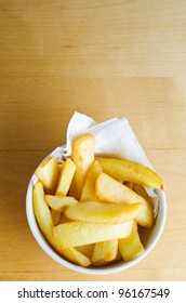 A Bowl Of Chips (french Fries) From Above On A Wooden Table.  Copy Space Above.  Vertical (portrait) Orientation.