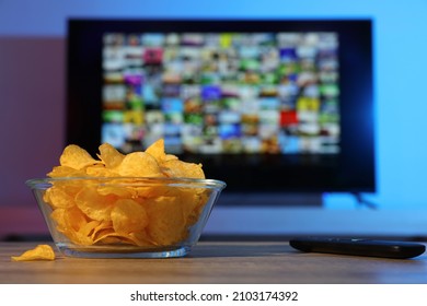 Bowl Of Chips And TV Remote Control On Table Indoors