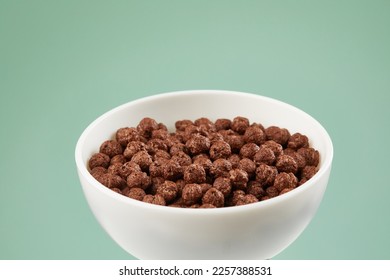 Bowl with chocolate balls. dry breakfast. crunchy corn balls with cocoa on color background. High quality 4k footage