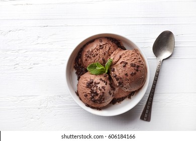 Bowl Of Chocolate Ice Cream On White Wooden Background. From Top View