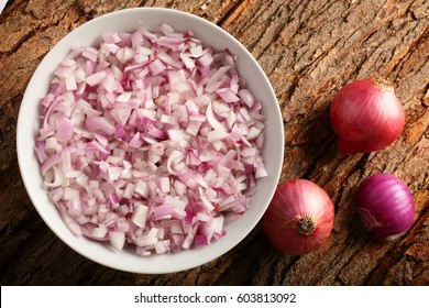 Bowl Of Chopped Red Onions On A Wooden Background.