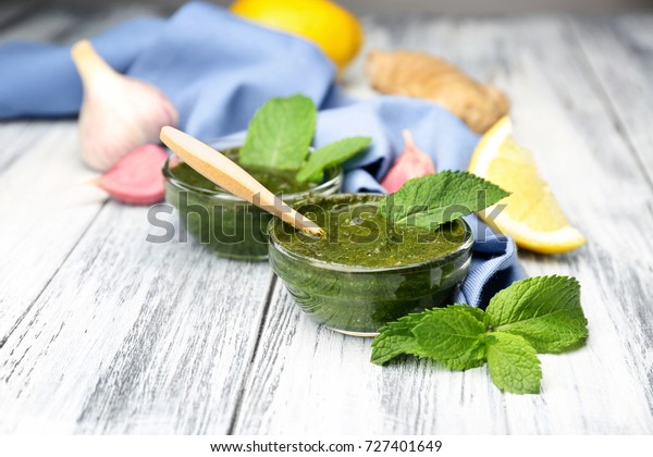 Bowl with chutney mint\
sauce on table