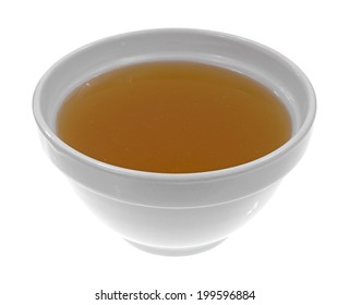 A Bowl Of Clear Chicken Broth On A White Background.