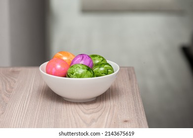 A Bowl Of Colored Easter Eggs On A Counter