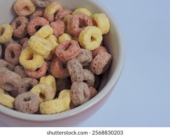 A bowl of colorful cereal with fruit flavors on top on a white table, the focus of the color and texture of the cereal is tempting. Perfect for a healthy breakfast or snack concept - Powered by Shutterstock