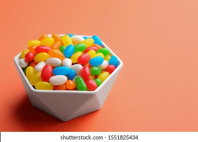 Bowl with colorful jelly beans on coral background. Space for text - Powered by Shutterstock